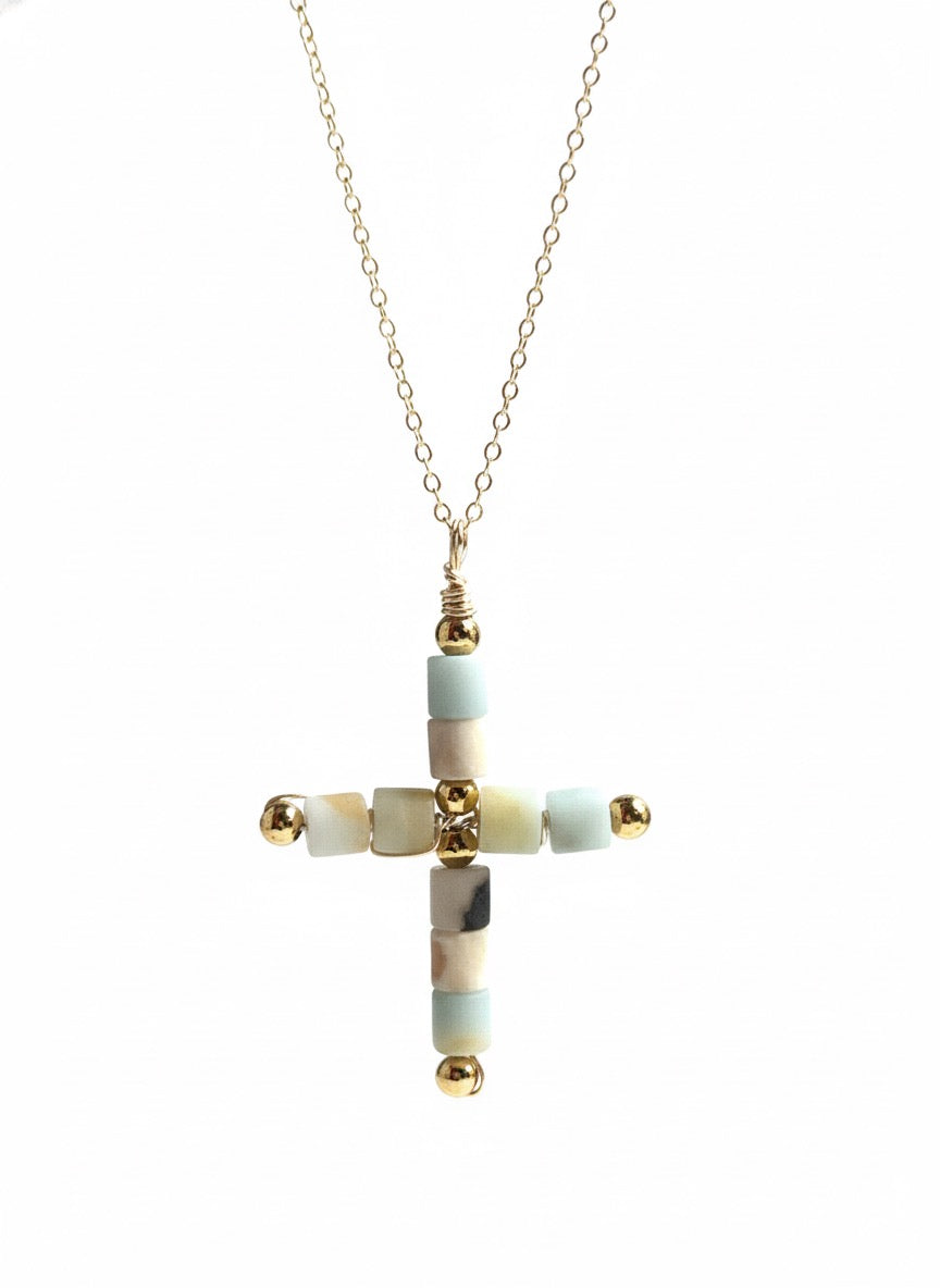 Close up of natural agate stone cross pendant showing unique banding patterns